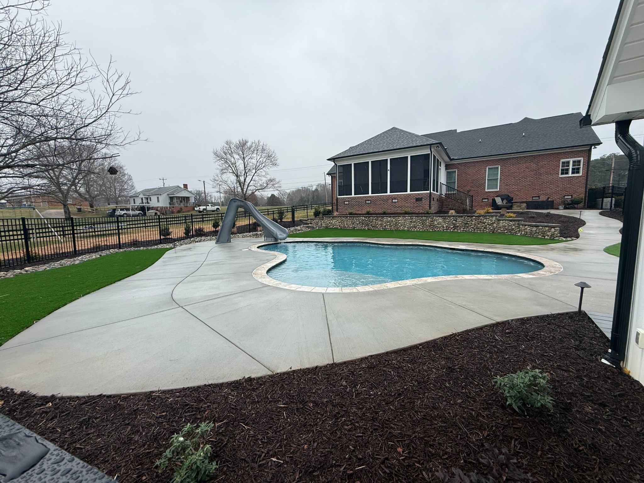 Freeform concrete pool with spa and water feature
